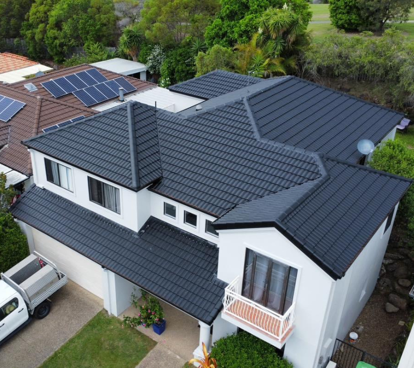 Two-storey home repainted white with a charcoal tiled roof