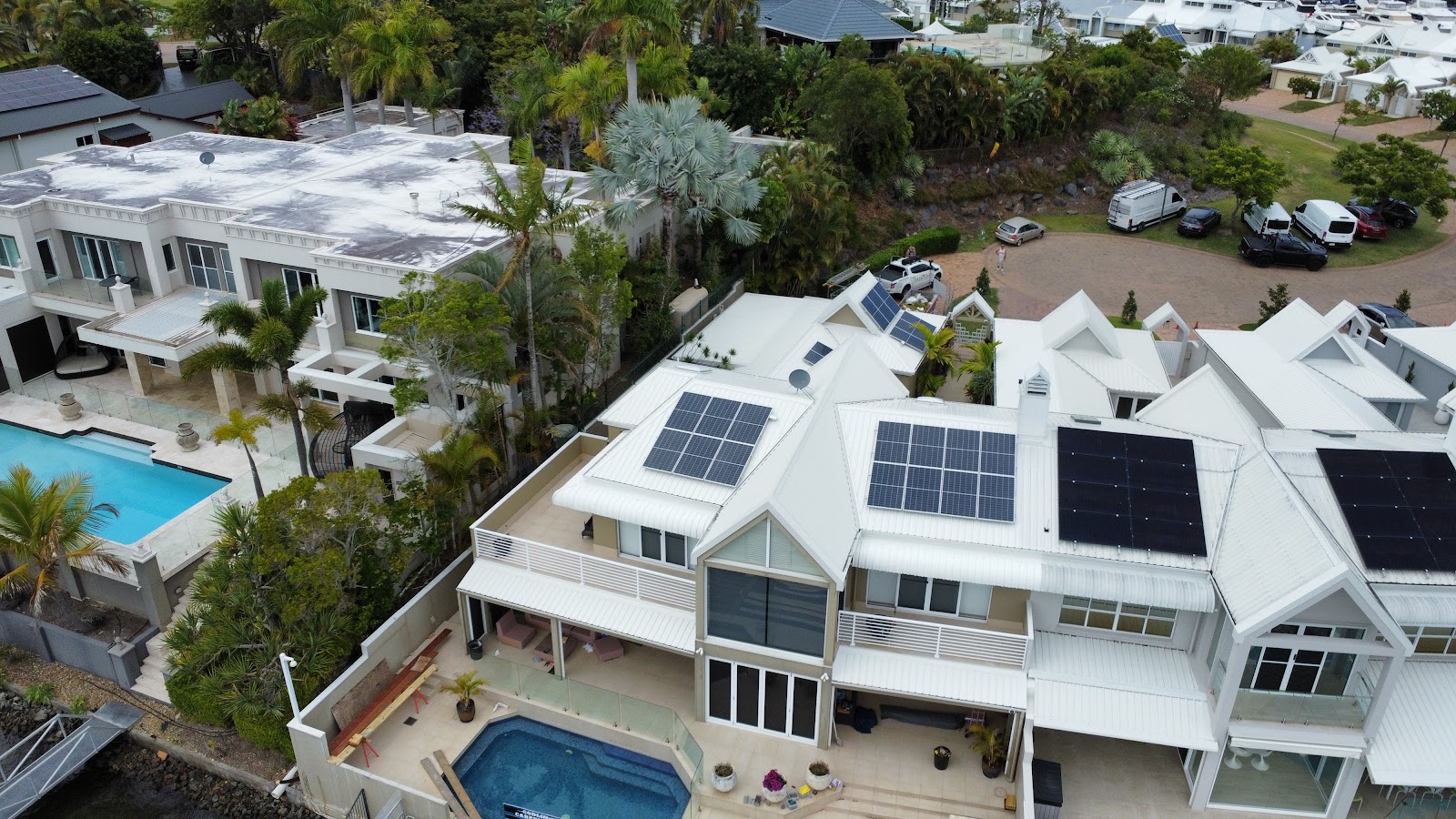Aerial view of white multi-level homes with freshly painted roofs