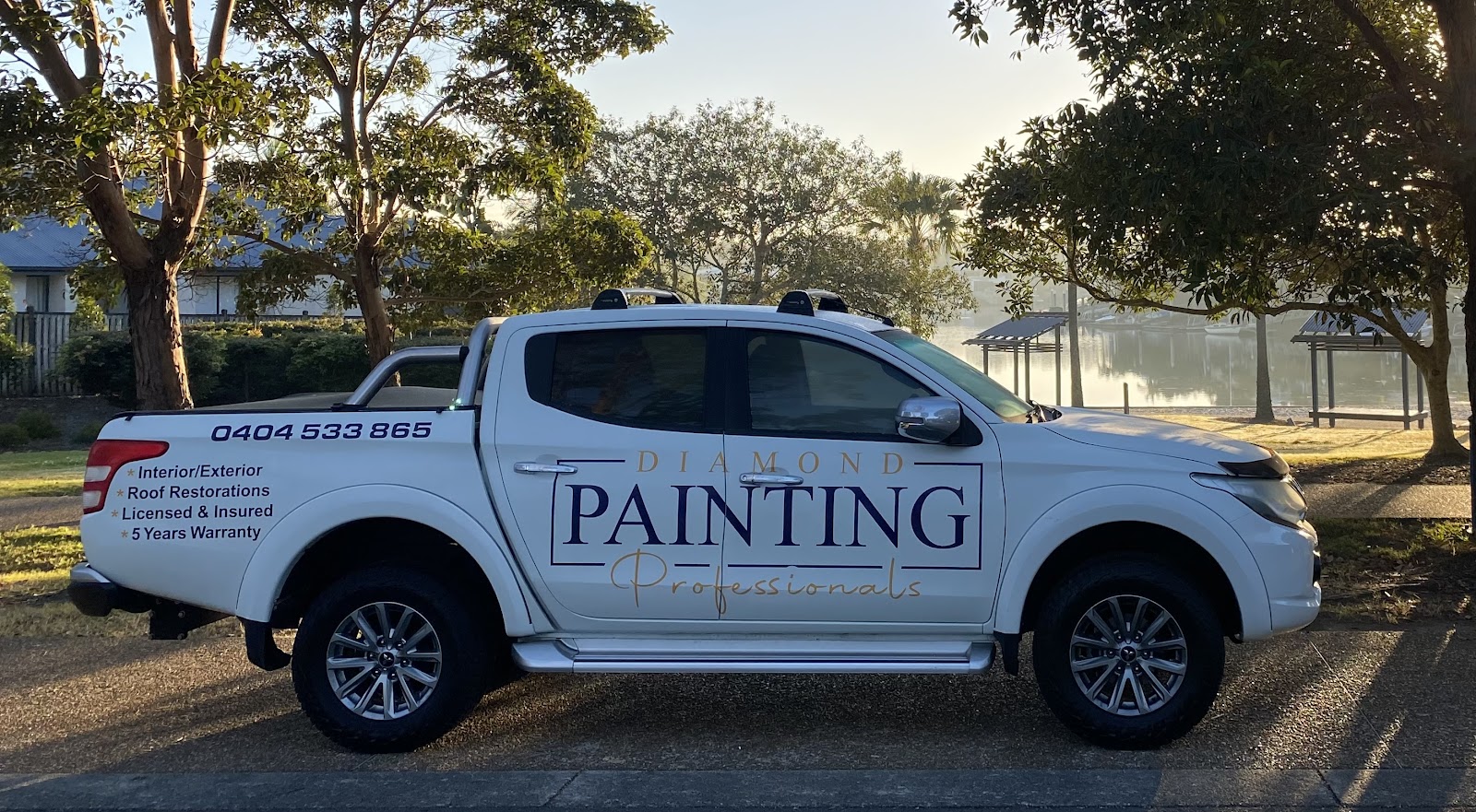 The white Diamond Painting Professionals ute, signwritten with the business name and phone number