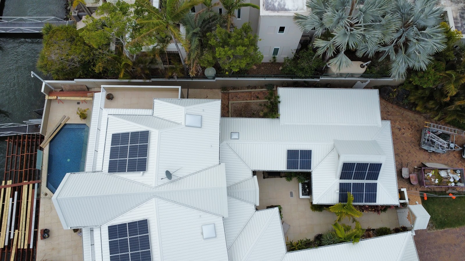 Aerial view of a freshly painted white roof beside a pool