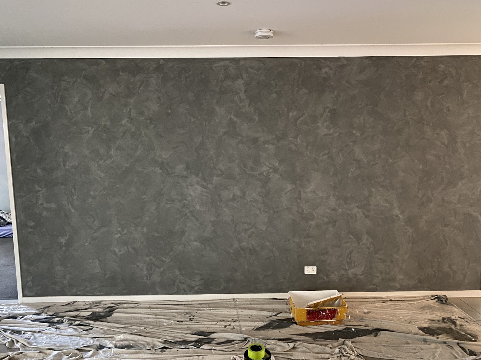 A dark textured feature wall painted in a living room