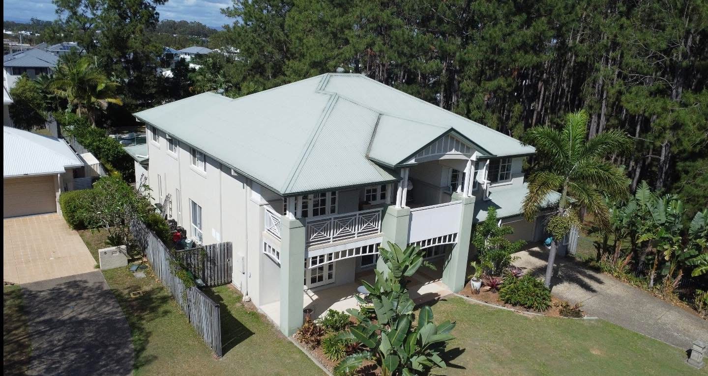 Before: the double storey house with a pale green roof and cream walls